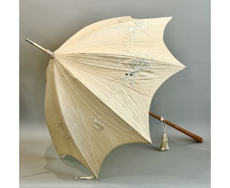 An Oriental parasol - first half 20th century, the ivory silk shade embroidered with a long-bodied dragon and a flaming pearl