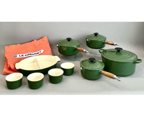 Four Le Creuset dark green enamel cast iron pans - comprising a 24cm round casserole with lid; and a graduated set of three 2