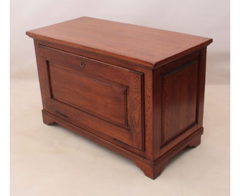A panelled oak cabinet by Clover Oak - the cleated top over a panelled fall front and panelled sides, on bracket feet. (LWH 1