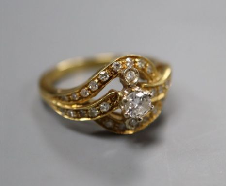 An 18ct yellow gold and diamond ring of scroll design, size O, gross 6 grams.