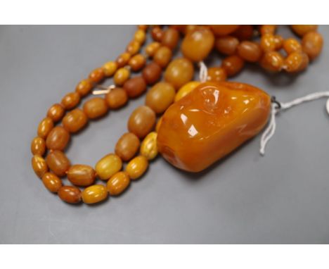 Four assorted amber bead necklaces (1 a.f.) and an amber boulder pendant, gross weight 82 grams.