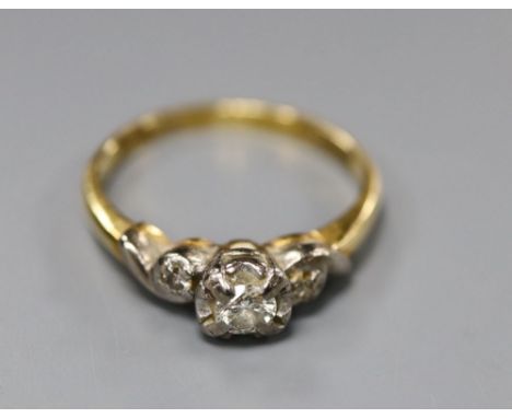 A three-stone diamond ring illusion-set in 18ct gold and platinum, size M, gross 2.9 grams.