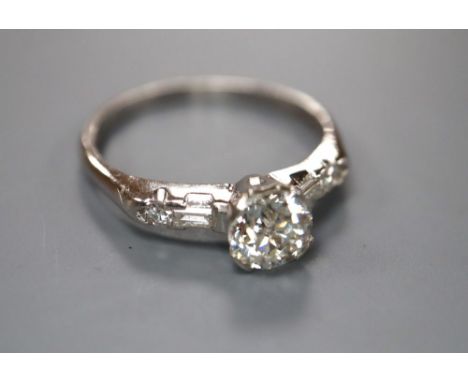 A modern white metal (stamped iridium and plat) and single stone diamond ring, with baguette and round cut diamond set ring, 