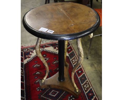 A Regency gilt and ebonised circular walnut occasional table, on triple ram's head support, diameter 47cm, height 78cm