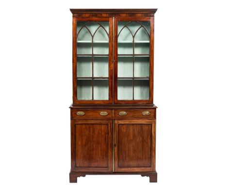 A 19th Century mahogany bookcase:, the upper part with a moulded dentil cornice, enclosed by a pair of pointed Gothic arch as