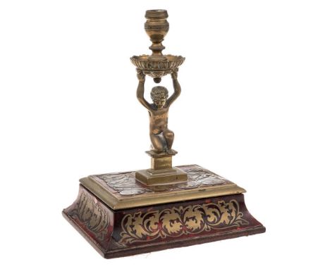 A 19th century boulle work and brass taperstick: the urn-shaped nozzle with foliate decorated drip tray supported by a putto 