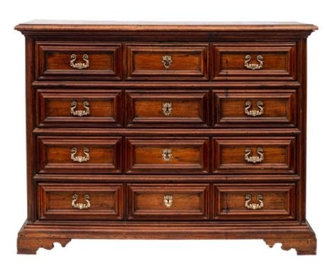 An 18th Century Italian provincial walnut commode:, of large size, the top with a moulded edge, containing four long geometri