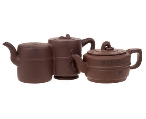 Two Chinese Yixing stoneware teapots: one of mid brown hue of squat and banded cylinder form with grotesque mask spout, the c