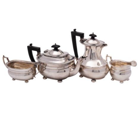 A George V silver four- piece tea service, maker Harrods, Birmingham, 1935: of barge-shaped outline, with gadrooned rims and 