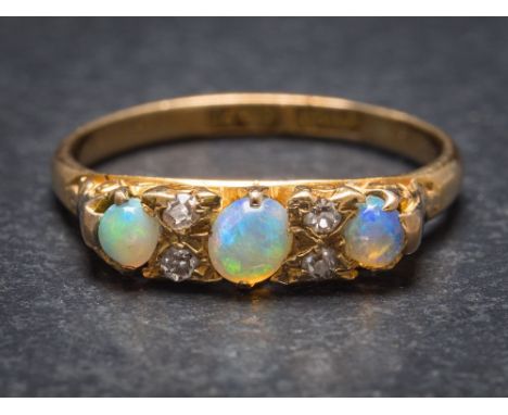 An 18ct gold, opal and diamond seven-stone ring: Chester assay marks to shank, ring size K 1/2. 