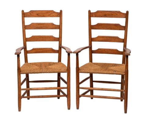 Cotswold School - A pair of oak Clissett ladder back armchairs in the manner of Edward Gardiner: with shaped arm supports and