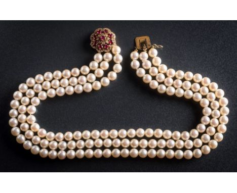 A cultured pearl three strand choker necklace with attached 18ct gold, ruby and diamond circular clasp: the individually knot