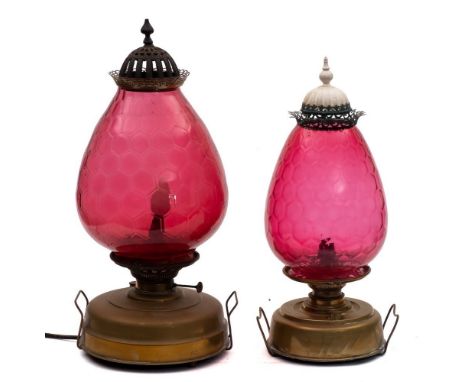 A brass oil fired storm lantern: the circular brass reservoir with large ruby glass shade, (converted to electricity), togeth