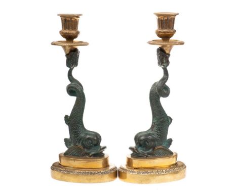 A pair of Regency style brass and bronzed metal metal candlesticks: with urn -shaped  nozzles, raised on dolphin supports and