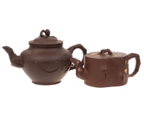 Two Chinese Yixing stoneware teapots: one of dark brown hue with rustic handle, spout extending into the body as flowering br