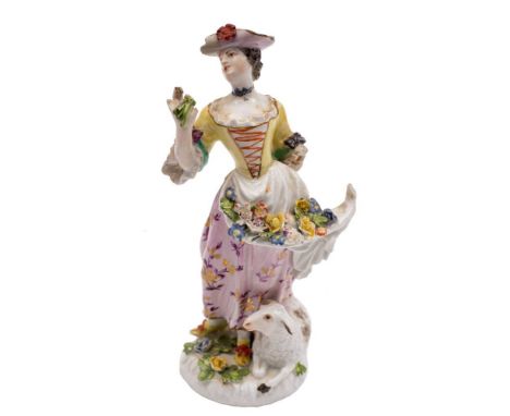 Two Meissen figures: the first of a shepherdess, wearing a yellow bodice, with  flowers in her apron and a ewe at her feet, o