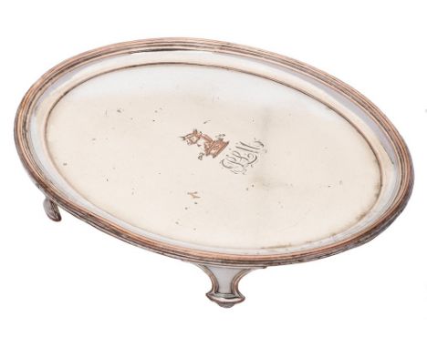 A 19th century Sheffield plate teapot stand: crested and initialled, of oval outline with a reeded border, raised on four swe