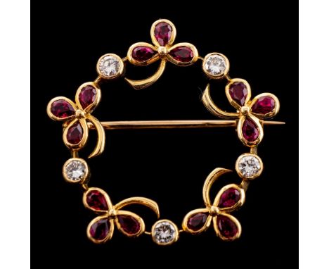 An 18ct gold, ruby and diamond mounted round garland brooch: with clover-leaf clusters of pear-shaped rubies, estimated to we