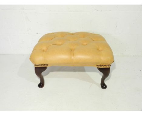 A leather footstool with button detailing 