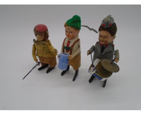 Three vintage Schuco clockwork tinplate toys including a gentleman drinking from a stein wearing traditional German costume, 