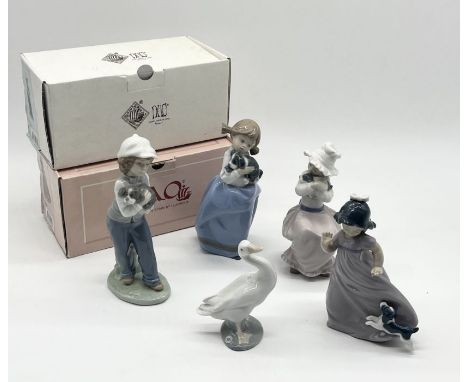 A collection of Nao figures including two in boxes and a Lladro duck 