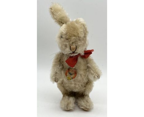 A Steiff Niki rabbit with mohair fur, stitched nose, silver button to ear and original tag