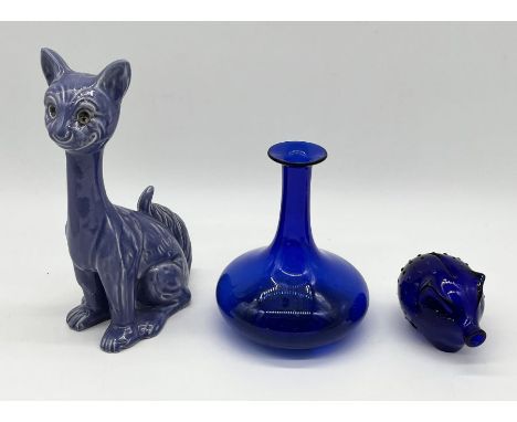 A blue glass piggy bank and decanter (no stopper) along with a pottery cat 