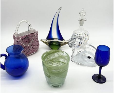 A collection of glassware including Laguna handbag, decanter, blue glass jug, Bohemia cat etc. 