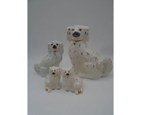 A collection of four ceramic Staffordshire dogs, including two by Royal Doulton