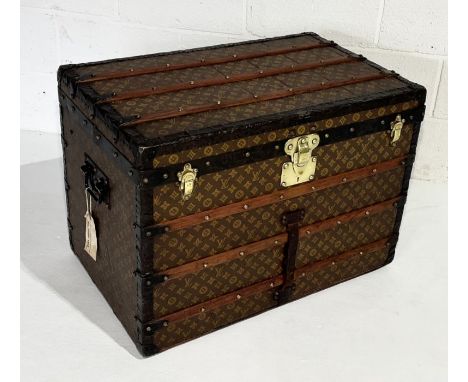 A large Louis Vuitton monogrammed steamer trunk circa 1900, wood bound with brass fittings and inner basket. Label for 1, Rue