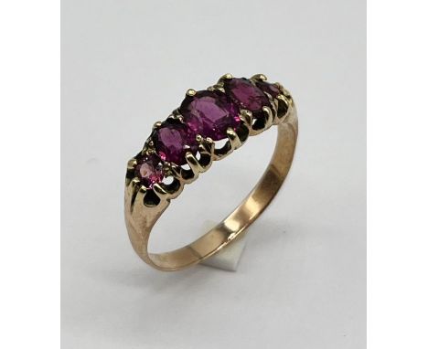 An unmarked gold garnet five stone ring