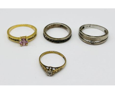 A small sized diamond solitaire ring in 9ct gold along with two 925 silver rings and one other