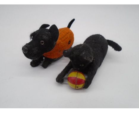 A vintage Schuco clockwork tinplate dog, along with another similar in the form of a cat playing with a ball