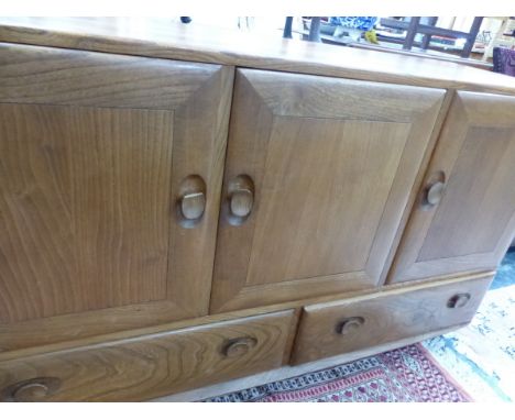 AN ERCOL PALE ELM SIDE BOARD. 