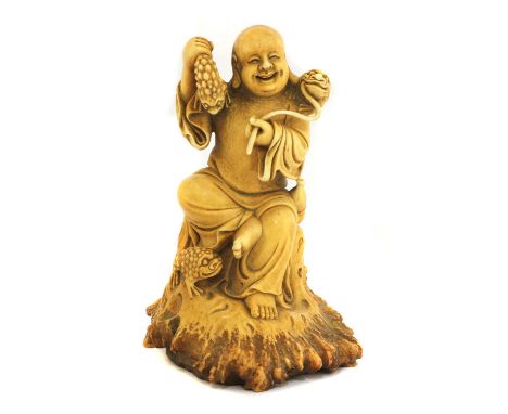 A Chinese stag antler carving of Liu Hai, wearing a long robe carrying a double gourd to his waist, seated on a section of tr