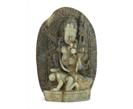 A Chinese jade bodhisattva, standing with a Buddhist attribute in each of his hands, his left leg straight and pressing on th