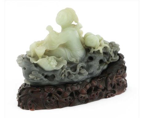 A Chinese jade carving, of a girl rowing a boat made from a pine trunk, above spuming waves, surrounded by lingzhi and peache