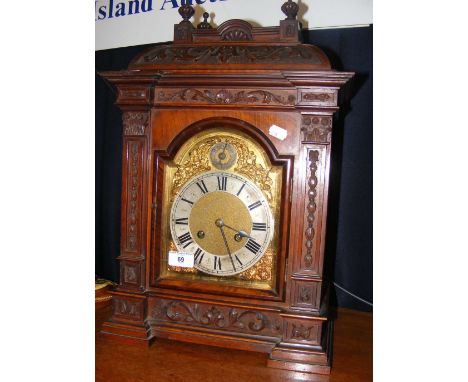 An antique bracket clock with carved wooden surround and striking movement - 53cm high