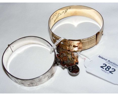 A silver bangle, brooch, etc.