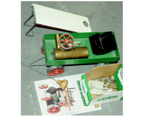 Mamod 4-wheeled Trailer for Live Steam Engines and spare parts - the trailer is green with red spoked wheels.  Spare parts in