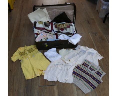 Vintage suitcase of quilted fabric and vintage children's clothes
