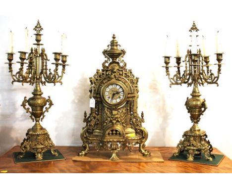 German made ornate brass mantel clock marked Imperial, 60 cm high, and pair of brass candelabra, 68 cm high.
