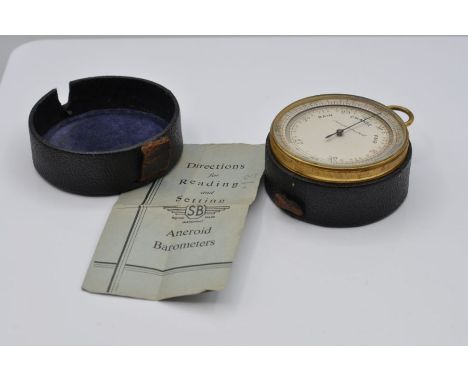 An aneroid pocket barometer with a 6.5cm silvered dial marked 'Compensated'  in a leather covered travelling case, 7cm wide w