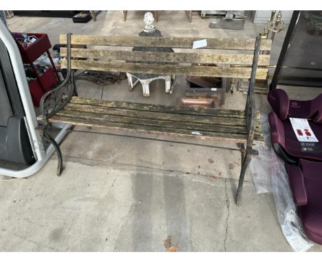 A WOODEN SLATTED GARDEN BENCH WITH CAST ENDS 