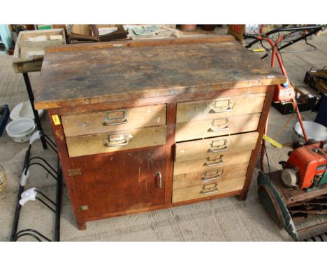 A VINTAGE WOODEN WORK BENCH WITH 8 DRAWERS AND A LOWER CUPBOARD (L:119CM) 