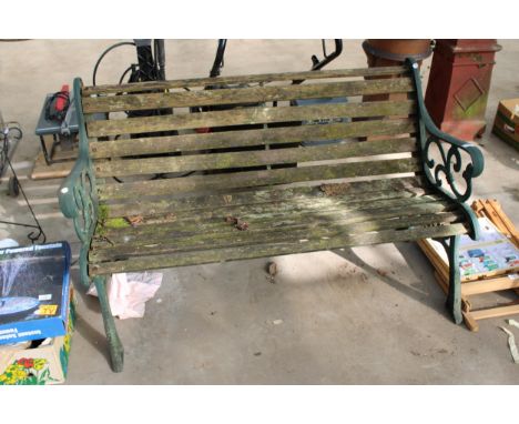 A WOODEN SLATTED GARDEN BENCH WITH DECORATIVE CAST BENCH ENDS 