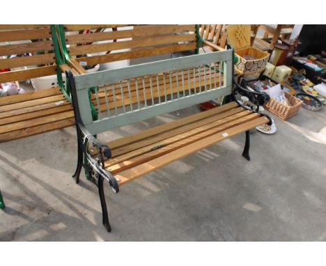A WOODEN SLATTED GARDEN BENCH WITH DECORATIVE CAST BENCH ENDS 