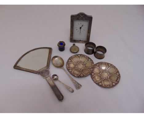 A quantity of silver and white metal to include a silver mounted desk clock, a perfume bottle, a pair of napkin rings, two sp