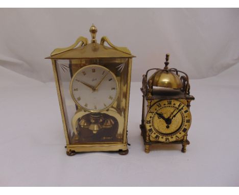 A Schatz gilt metal and glass revolving pendulum mantle clock and a miniature brass lantern clock in 17th century style