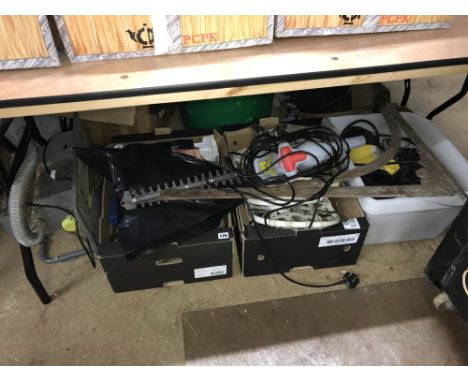 Under table: tools, including saw bench and hedge trimmer